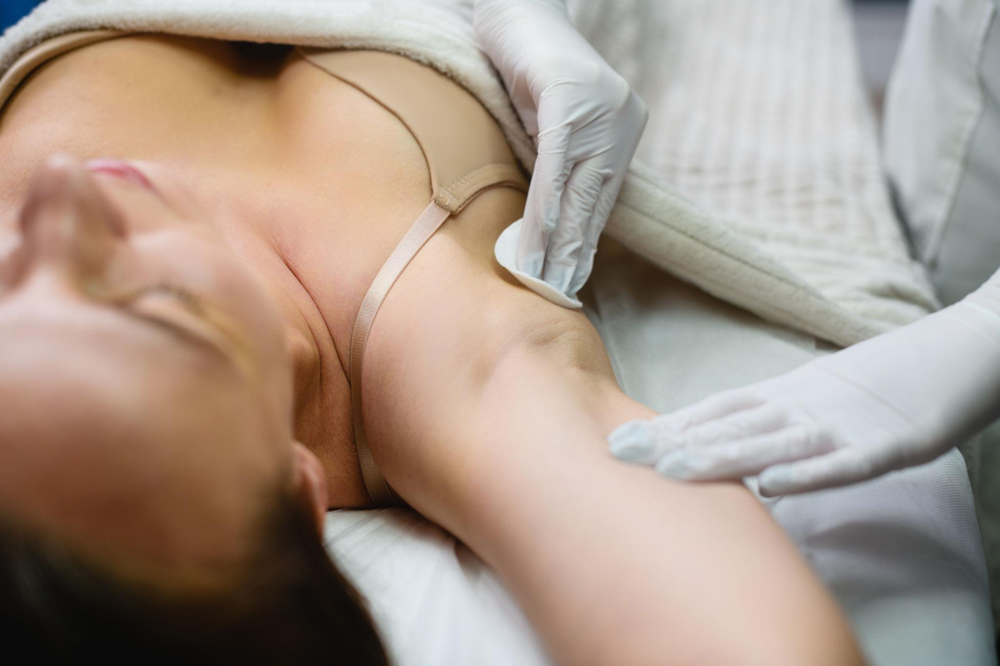 Medical professional performing an ultrasound on a patient's underarm.
