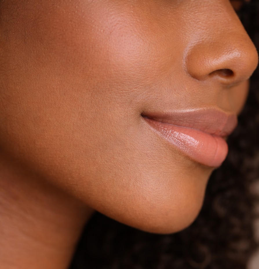 Close-up of a smiling person's lips and cheek.